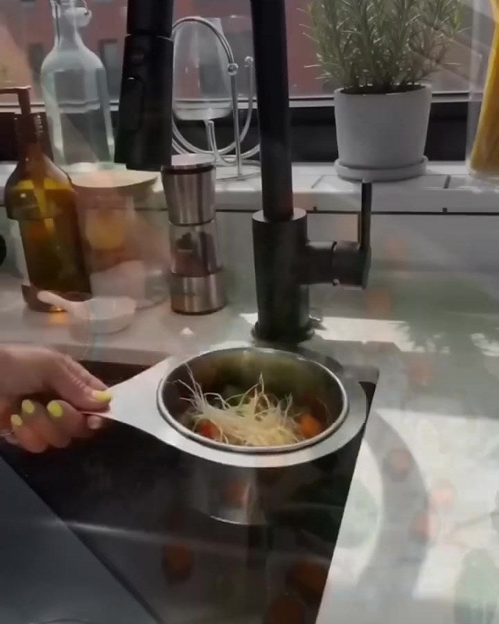 The strainer basket lifted out of a kitchen sink drain